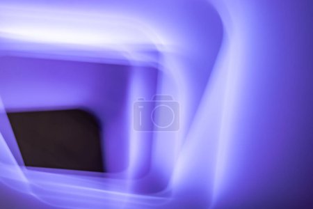 Foto de Una imagen abstracta que muestra un cuadrado violeta profundo rodeado de tonos suaves y luminosos de púrpura. Los bordes lisos y borrosos crean una sensación de profundidad y dimensión, llevando el ojo del espectador hacia el centro.. - Imagen libre de derechos