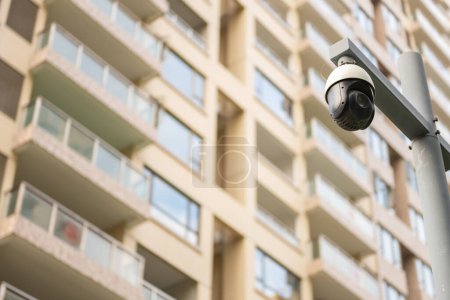 Téléchargez les photos : Caméras de vidéosurveillance et bâtiment résidentiel sur la composition horizontale arrière - en image libre de droit
