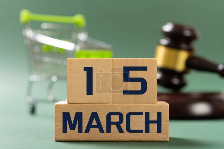 Foto de MARCH 15 in front and shopping cart and judge gavel on back concept of world consumer rights day - Imagen libre de derechos