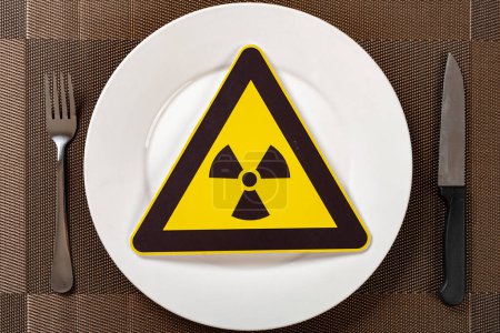 Foto de Señal de advertencia de radiación nuclear en un concepto de plato de alimentos inseguros - Imagen libre de derechos