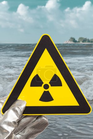Foto de Señal de advertencia de radiación nuclear frente a una composición vertical oceánica - Imagen libre de derechos
