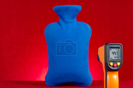 Téléchargez les photos : Thermomètre infrarouge montre la température de surface d'une bouteille d'eau chaude - en image libre de droit