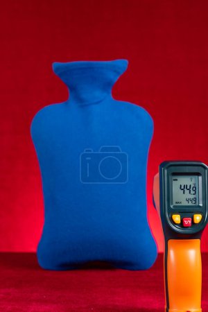 Téléchargez les photos : Thermomètre infrarouge montre la température de surface d'une bouteille d'eau chaude composition verticale - en image libre de droit