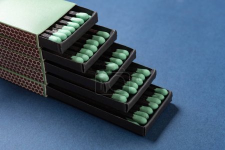 angle view green matchboxes on a blue background at horizontal composition