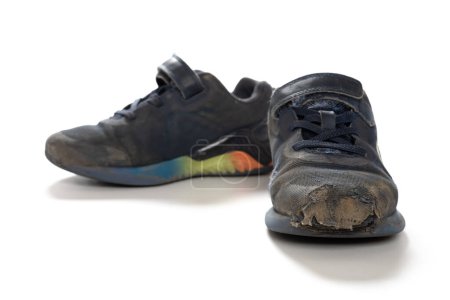 Téléchargez les photos : Paire de chaussures de sport cassées pour enfant sur fond blanc - en image libre de droit