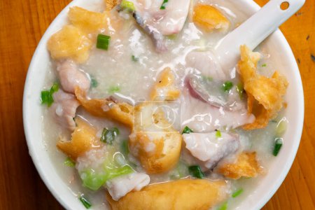 top view fish slices and pork porridge with deep-fried Chinese donuts at horizontal composition