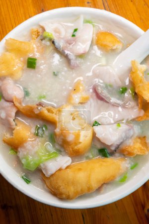 top view fish slices and pork porridge with deep-fried Chinese donuts at vertical composition