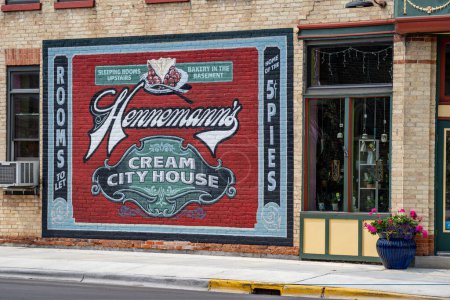 Foto de Algoma, Wisconsin - 3 de junio de 2023: Mural y signo para la famosa Hennemanns Cream City House, que sirve pasteles y otros productos horneados en el centro de la ciudad - Imagen libre de derechos
