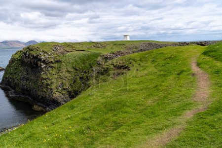 Foto de Vista lejana del faro blanco de Arnarstapi en Islandia - Imagen libre de derechos