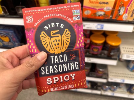 Photo for Plymouth, Minnesota - July 30, 2023: Hand holds up a Siete spicy taco seasoning packet while shopping at a supermarket - Royalty Free Image