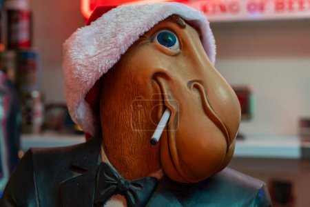 Foto de Arizona, Estados Unidos - 22 de diciembre de 2023: Vintage Joe Camel mascot from Camel Cigarettes, wearing a santa hat. Joe Camel promocionó cigarrillos en las décadas de 1980 y 1990 - Imagen libre de derechos