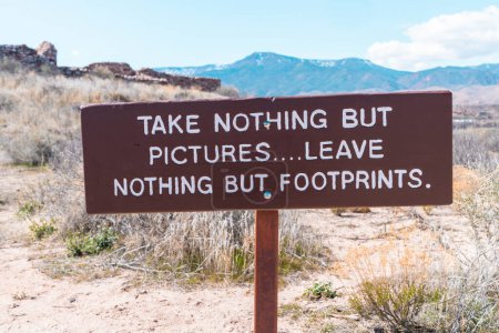 Take nothing but pictures leave nothing but footprints motto on a sign