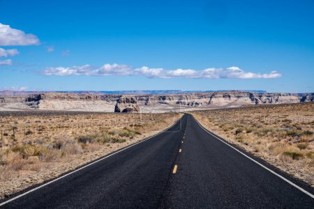 Camino que conduce a Lake Powell, Arizona. Camino solitario del desierto con cielo azul