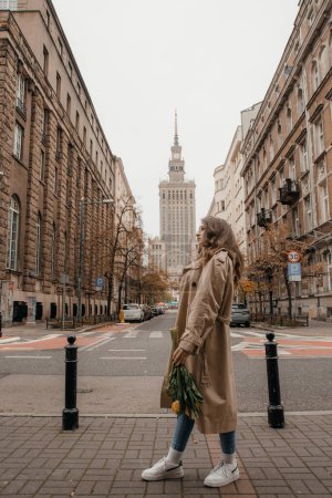 Téléchargez les photos : Concept de style de vie Pologne et les villes de voyage à Varsovie. Femme ont un beau bouquet de tulipes jaunes debout à l'extérieur à Varsovie. - en image libre de droit