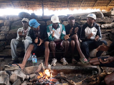 Téléchargez les photos : ANDRINGITRA NATIONAL PARK. MADAGASCAR - NOVEMBER 15, 2022: Porters prepare food in a primitive hut. November 15.2022 Andringitra National Park. Madagascar. - en image libre de droit