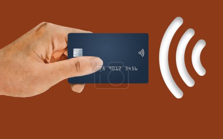 A hand holds a credit card next to a NFC near field communication or wi-fi  icon in this 3-d illustration about credit card security and convenience.