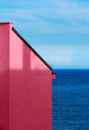 Téléchargez les photos : Viva magenta mur de bâtiment avec un fond de mer et ciel. Concept abstrait minimal. Couleur tendance année 2023. - en image libre de droit