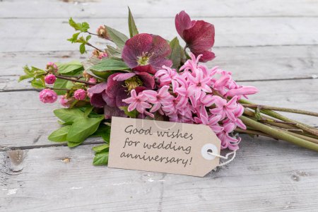 Strauß mit rosa Hyazinthen, Weihnachtsrosen und Karte mit englischem Text: Gute Wünsche zum Hochzeitstag
