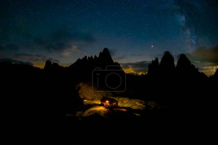 Photo for Green tent lighted from the inside against the backdrop of incredible starry sky and Three Peaks of Lavaredo mountains. National Park Tre Cime di Lavaredo, Dolomites, Italy. Landscape photography - Royalty Free Image