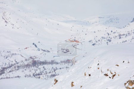 Foto de Paisaje de invierno con pequeñas casas de pueblo entre el bosque cubierto de nieve en montañas frías. Giresun - Turquía - Imagen libre de derechos