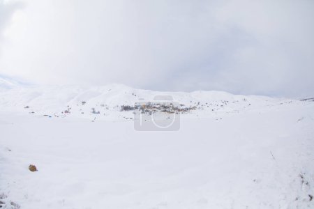 Foto de Paisaje de invierno con pequeñas casas de pueblo entre el bosque cubierto de nieve en montañas frías. Giresun - Turquía - Imagen libre de derechos