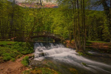 Beutiful waterfall under a wooden bridge