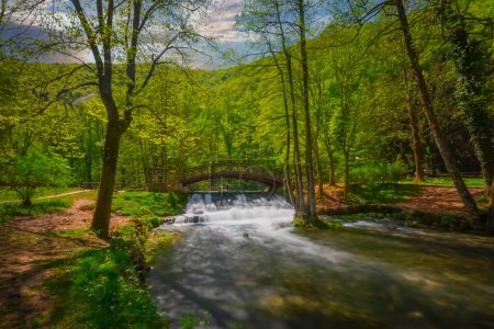 Schöner Wasserfall unter einer Holzbrücke