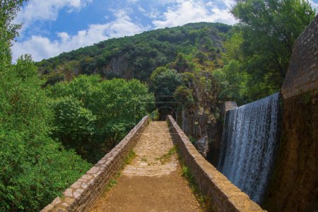 La antigua piedra, puente arqueado, entre dos cascadas en Palaiokaria, prefectura de Trikala, Tesalia, Grecia.
