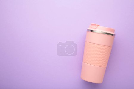 Photo for Pink thermo cup or thermos mug for tea or coffee on purple background. Hot beverage. Top view - Royalty Free Image