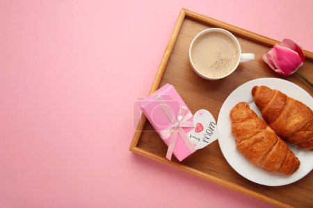 Glücklicher Muttertag, schönes Frühstück, Mittagessen mit einer Tasse Kaffee, frischen Croissants, Tulpe und Geschenk. Frühjahrsferien, Familienbeziehungen. Ansicht von oben