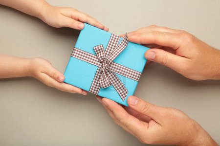 Photo for Father's day gift with daughter or son holding dad's hands giving present box to tell I love you dad, I am so thankful and happy fathers day. Top view - Royalty Free Image
