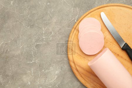 Boiled pork sausage on cutting board on grey background. Top view