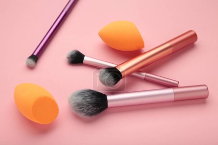 Make-up Pufferpinsel und Beauty Make-up Schwämme auf rosa Hintergrund. Schönheits- und Makeup-Konzept. Ansicht von oben