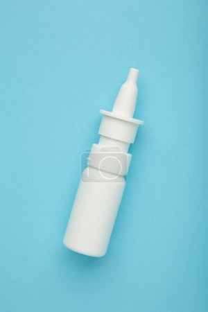 Photo for Bottle of nasal drops on blue background. Vertical photo. Top view - Royalty Free Image