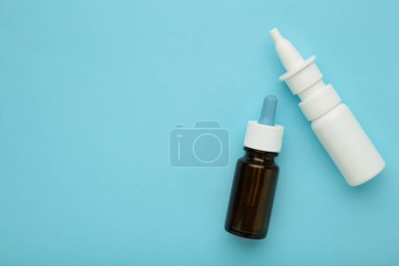 Photo for Bottles of nasal drops on blue background. Space for text. Top view - Royalty Free Image