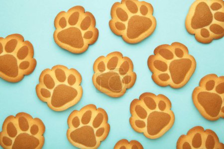 Self made cat paw cookies on blue background. Top view