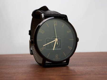 Foto de Water resistant black watch with leather strap placed on a desk - Imagen libre de derechos