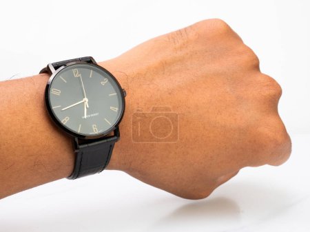 Foto de Water resistant black watch with leather strap wear by asian man on left hand - Imagen libre de derechos
