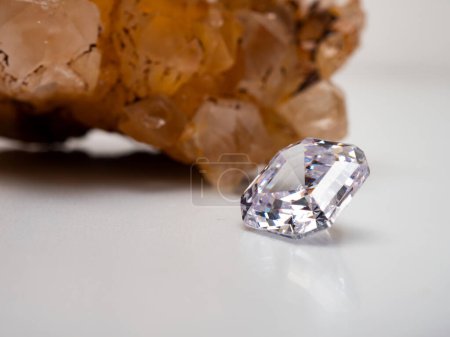 Téléchargez les photos : Side view of a sparkling asscher cut diamond with rough stone background - en image libre de droit