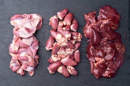 Raw chicken giblets raw poultry meat set : liver, stomach gizzard and heart . Top view 