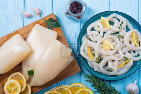 Fresh seafood background .  Squid rings and tubes with lemon  rosemary .
