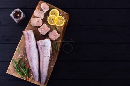 Raw hake on wooden background . ready to cooking top view