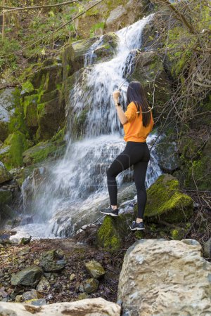 Foto de Mujer de pie frente a la cascada - Imagen libre de derechos