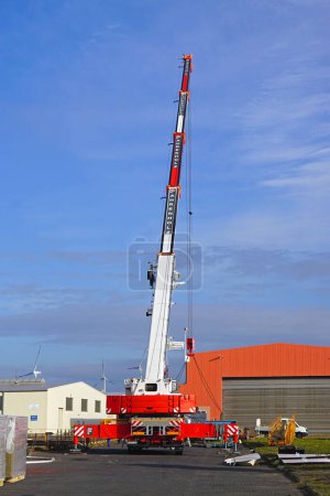 Photo for Bremerhaven, Germany - October 20, 2018: Lifiting heavy load with mobile crane truck Fahrenholz nice weather calm day at port. - Royalty Free Image