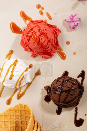 Chocolate fruit and vanilla ice cream scoops with caramel topping and waferstick