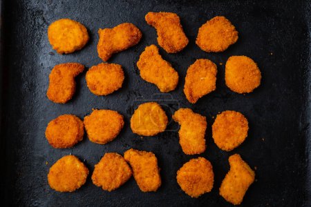Photo for Overhead view of crisp nuggets on black surface fast food - Royalty Free Image