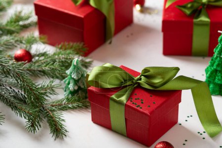 Foto de Primer plano de la caja de regalo de Navidad roja con arco verde y ramas de abeto - Imagen libre de derechos
