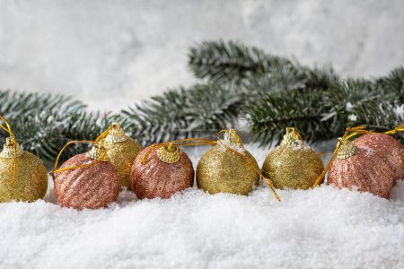 Foto de Concepto de Navidad con nieve y decoraciones rosa y oro bolas ramas verdes copiar espacio - Imagen libre de derechos