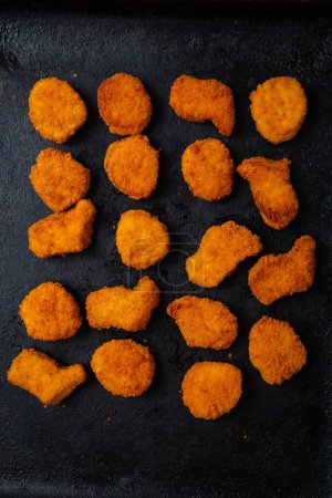 Foto de Vista superior de pepitas de pollo en la superficie oscura patrón fastfood - Imagen libre de derechos