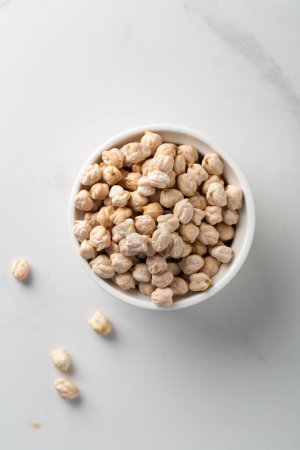 Top view of uncooked chick pea beans in bowl